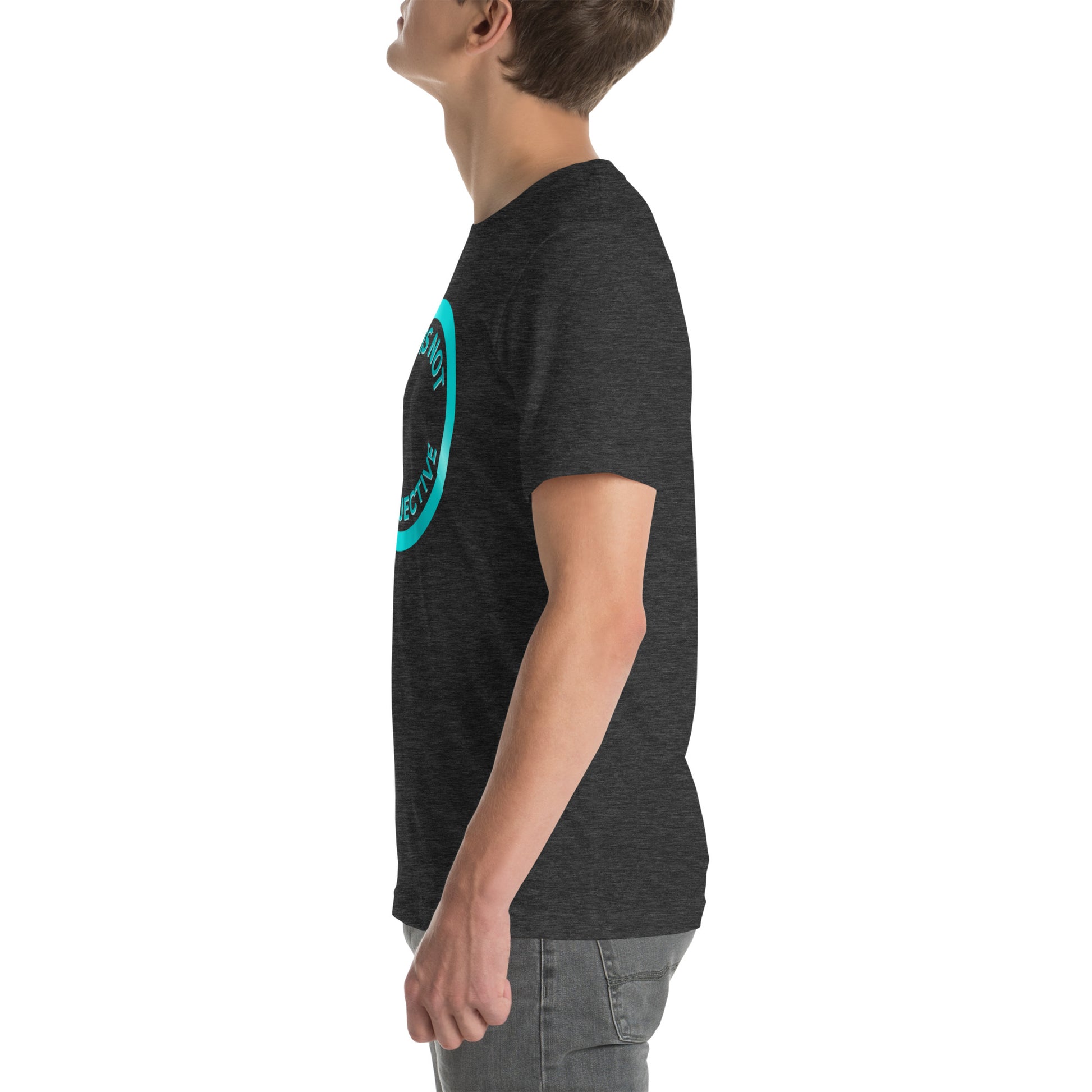 A person in profile wears the "OCD Is Not An Adjective" dark gray combed cotton t-shirt by NeuroNiche Design, featuring a blue circular chest design. Paired with gray jeans, they look upward against a plain white background.