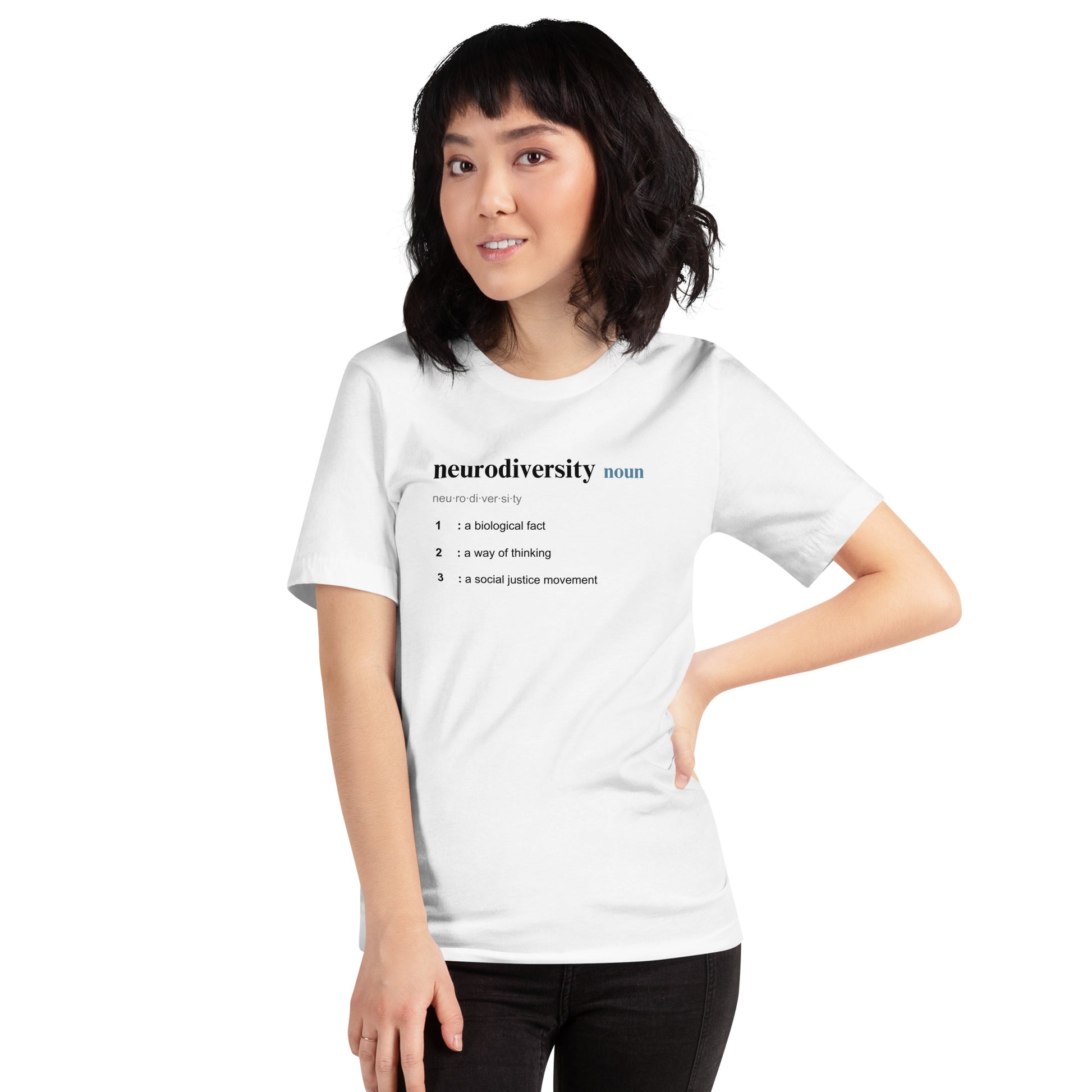 A person with medium-length dark hair wears NeuroNiche Design’s Defining Neurodiversity 100% cotton white shirt, featuring the phrase "neurodiversity noun" and three definitions: a biological fact, a way of thinking, and a social justice movement.