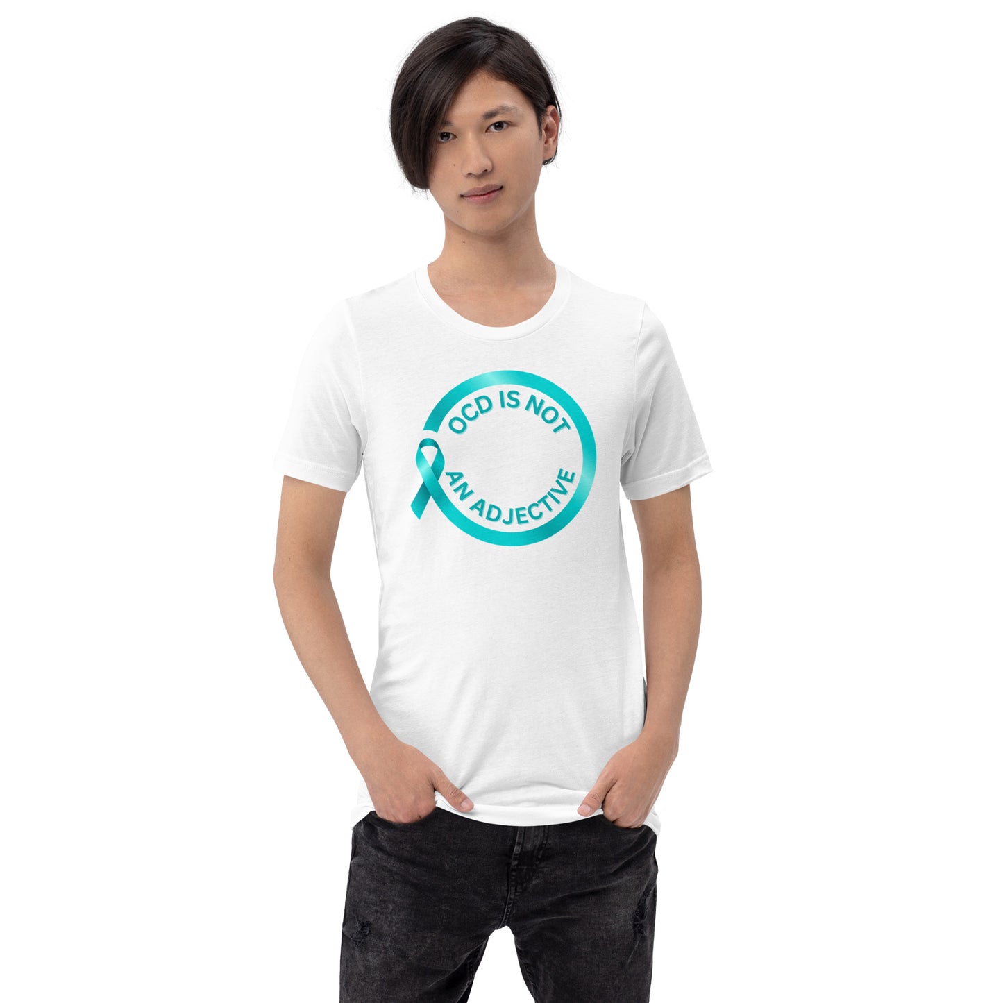 A person with straight dark hair wears the 'OCD Is Not An Adjective' 100% cotton t-shirt by NeuroNiche Design, featuring a teal awareness ribbon and message in a teal circle, standing with one hand in their pocket against a plain background.