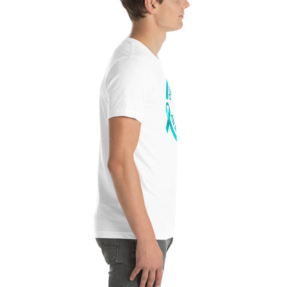 A person stands in profile against a white background, wearing NeuroNiche Design's "OCD Is Not An Adjective" white combed cotton t-shirt with a teal ribbon, partial text, and pre-shrunk fabric for lasting comfort, paired with gray jeans.